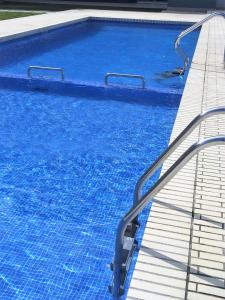 a swimming pool with blue water and stairs in it at Apartment Ramon in Sant Antoni de Calonge