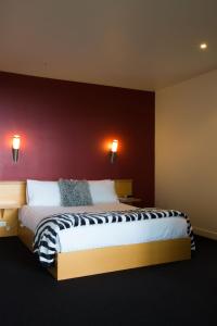 a bedroom with a large bed with a red wall at River Vineyard Retreat in Grindelwald