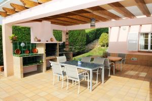 Un patio con mesa y sillas y una cocina. en Villa PANORAMA y Villa MIRADOR, en Son Bou