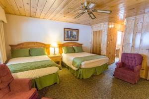 a hotel room with two beds and a chair at June Lake Motel in June Lake
