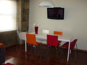ヴィラ・ノヴァ・デ・ガイアにあるCellars Flatの白いテーブル(オレンジの椅子付)、壁掛けテレビ
