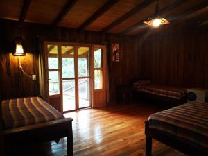 a living room with a wooden floor and a sliding glass door at Posada Camboatá in Aristóbulo del Valle