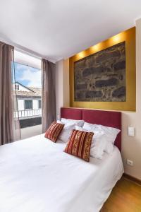 a bedroom with a large white bed with two pillows at Horta Garden in Horta