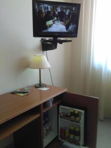 um quarto com uma televisão, um candeeiro e uma mesa em Hotel il Focolare em Fabro