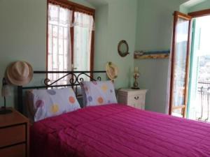 1 dormitorio con 1 cama con colcha rosa en Captains house, en Poros