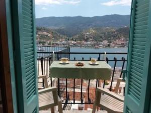 a table and chairs on a balcony with a view of the water at Captains house in Poros