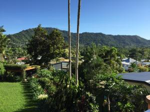 uma vista para um jardim com uma montanha ao fundo em Hideaway on Hillview em Cairns