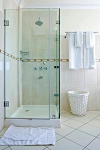 ナイロビにあるGemSuites Serviced Apartments State Houseの浴室のガラス扉付きシャワー