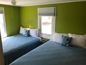 two beds in a room with green walls at Lighthouse Cabins in Old Orchard Beach