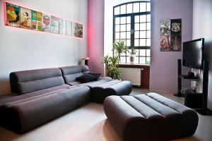a living room with a couch and a tv at Loft Suite in Łódź