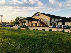 a building with cars parked in a parking lot at Pinckneyville Inn and Suites in Pinckneyville