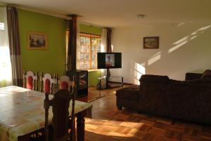 sala de estar con mesa, sofá y TV en La Casa Toesca, en Valdivia