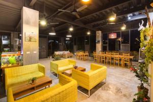 a restaurant with yellow couches and tables and chairs at 達芭凱民宿 Tabakai B&B in Xinyi
