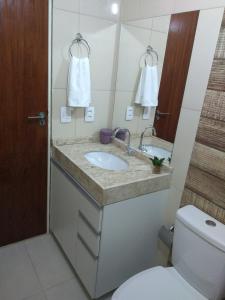 a bathroom with a sink and a toilet at Estúdio Ibiza em Jatiúca in Maceió