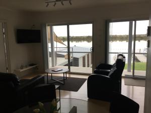 uma sala de estar com dois sofás e vista para a água em Washpool Retreat em Wellington East