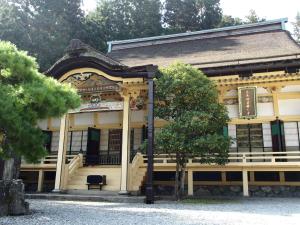 um edifício antigo com uma árvore em frente em Koyasan Shukubo Sainanin em Monte Koya