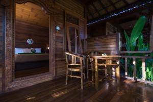una habitación con una mesa y sillas y una cama en Putra 7 Cottage, en Nusa Lembongan