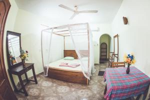 um quarto com uma cama e uma rede mosquiteira em Rupa's Hotel em Arugam Bay