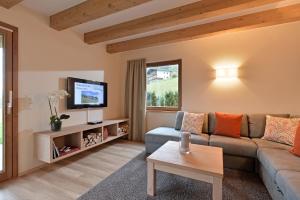 a living room with a couch and a tv at Resort Tirol Brixen am Sonnenplateau in Brixen im Thale