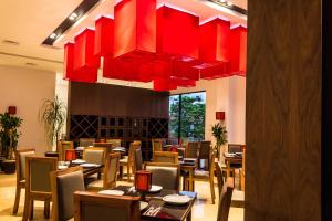 a restaurant with tables and chairs under a large red chandelier at Kabah Boutique Hotel in Cancún