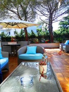 um pátio com uma mesa, cadeiras e um guarda-sol em Bed and Breakfast La Villa AMBIENTI SANIFICATI CON GENERATORE DI OZONO em Bari