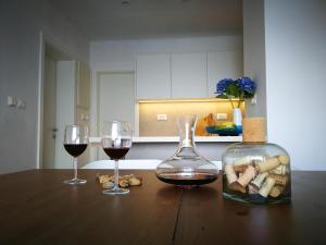 einen Tisch mit zwei Gläsern Wein und einer Flasche Wein in der Unterkunft Mljet 4You - Beach House in Sobra