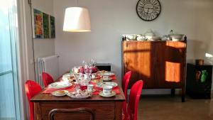 una mesa de comedor con sillas rojas y un comedor en Il Rifugio dello Scoglio, en Ostuni