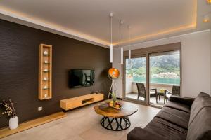 a living room with a couch and a tv and a table at Apartments Magic Sea View in Kotor