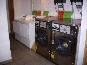 duas máquinas de lavar roupa sentadas uma ao lado da outra num quarto em O Albergue de Selmo em Arzúa