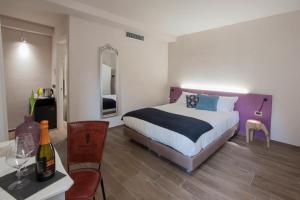 a bedroom with a bed and a table with a bottle of wine at Angolo Divino in Alba