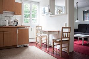 a kitchen and living room with a table and chairs at Hotel Flosdorff - Appartements in Monschau +12 photos