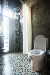 a bathroom with a toilet and a shower at Sweet Life Community Guesthouse in Ko Lanta