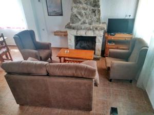 a living room with a couch and chairs and a fireplace at Magina Dream La Guardia Turismo Rural in La Guardia de Jaén
