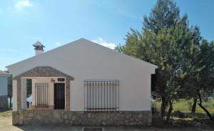 a small white building with a gate and trees at Magina Dream La Guardia Turismo Rural in La Guardia de Jaén