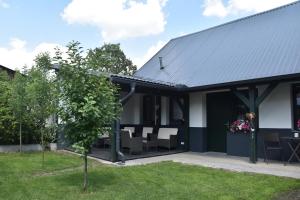 a house with a black roof and a patio at Na Útesu in Jindřichŭv Hradec