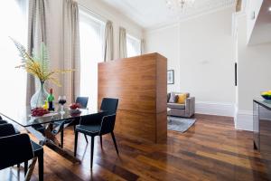 a dining room with a table and chairs at Lancaster Gate Hyde Park by London Hotel Collection in London