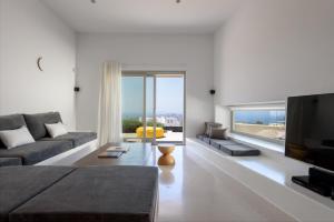Una sala de estar con un sofá y un televisor de pantalla plana. en Albus Villas, en Pirgos