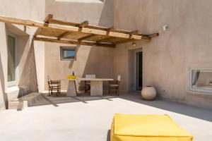 Un patio al aire libre con mesa y sillas. en Albus Villas, en Pirgos
