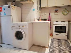 eine Küche mit einer Waschmaschine und einem Kühlschrank in der Unterkunft Wonderful Apartment in central Athens in Athen