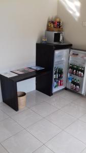 a black desk and a refrigerator with soda bottles at Gili Palms Resort in Gili Trawangan