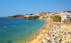 a group of people on a beach in the water at Dinita Apartamentos in Albufeira