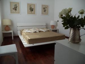 ein Schlafzimmer mit einem Bett und einer Vase aus Blumen in der Unterkunft Villa Aunti in Albinia