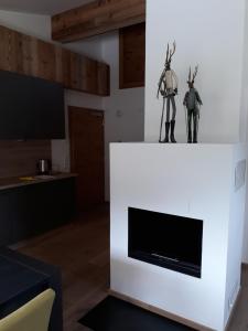 a fireplace with two statues on top of it at Haus Riefli- Monique in Sankt Anton am Arlberg