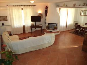ein Wohnzimmer mit einer weißen Couch und einem Kamin in der Unterkunft Villa Aunti in Albinia