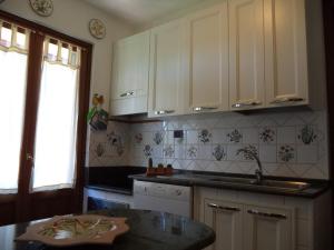 eine Küche mit weißen Schränken und einer Arbeitsplatte in der Unterkunft Villa Aunti in Albinia