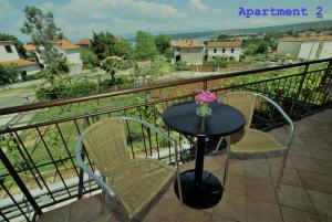 einen Tisch und zwei Stühle auf dem Balkon in der Unterkunft Apartments and Rooms Kod Keti in Malinska