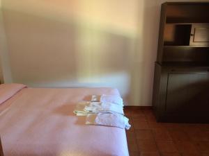 una camera con un letto e asciugamani pieghevoli di Hotel Vittoria a San Felice Circeo