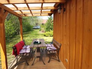 a patio with a table and chairs on a deck at Pod lipą in Ruciane-Nida