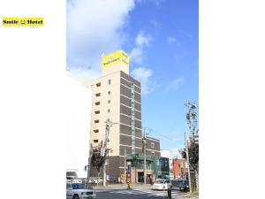 ein Gebäude mit einem gelben Schild darüber in der Unterkunft Smile Hotel Asahikawa in Asahikawa