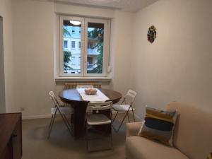 een woonkamer met een tafel en stoelen en een raam bij Appartamento Duca in Trento